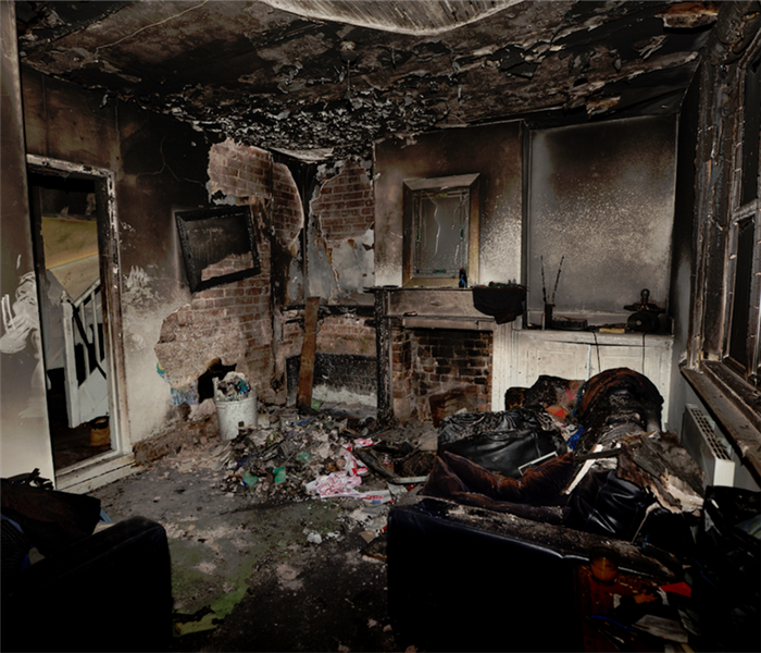 a fire damaged room with soot covering the walls and furniture