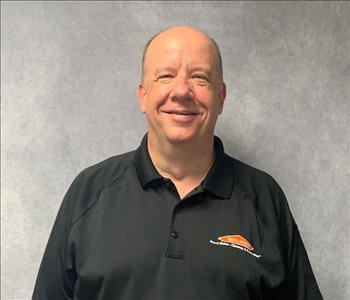 male employee, bald on top, black shirt posing