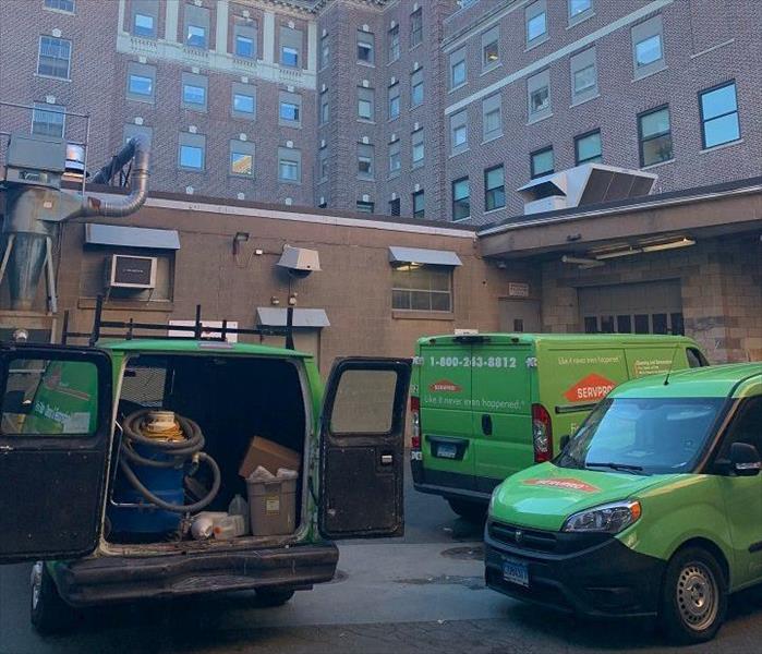 Three SERVPRO vehicles, with one open and showing some equipment