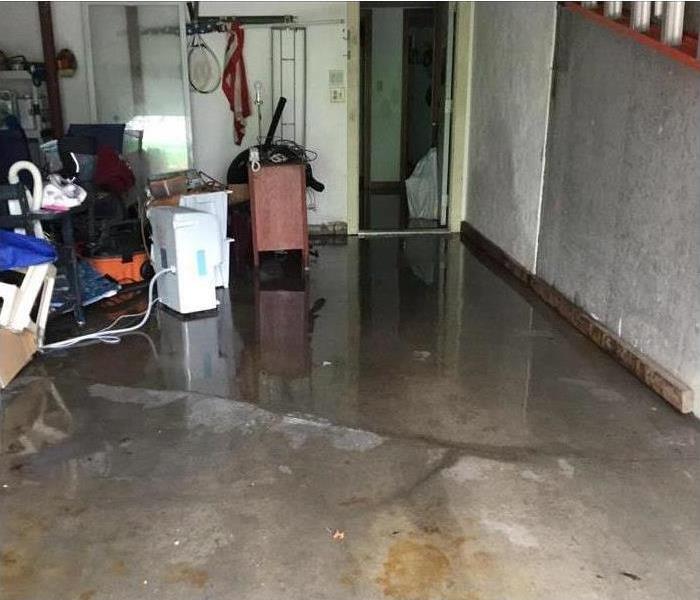 concrete pad basement with pooling water and some content at the side