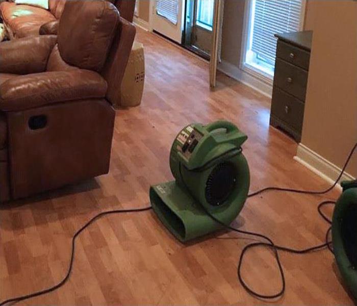 living room with hardwood floor, recliner and green fan