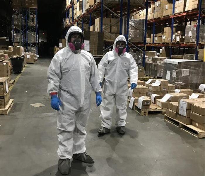 Two SERVPRO technicians in full PPE suits.